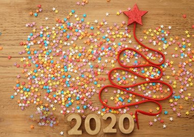 Bir çok renkli konfeti, dantel ve kırmızı yıldız oyuncak eski retro vintage tarzı ahşap doku üzerinde Noel ağacı. Mutlu yeni yıl 2020 kartı 