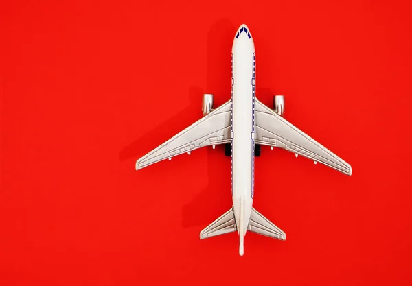 Metal Oyuncak Kırmızı Kağıt Arka Plan Uçakta Seyahat Ulaşım Fikir — Stok fotoğraf