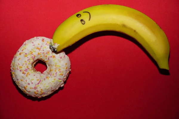 red donut and reap yellow banana isolated on red background. sex idea.