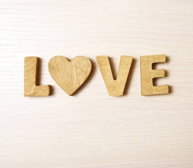 ahşap harfler ve kalp yapılan kelimesini seviyorum. ahşap arka plan. 