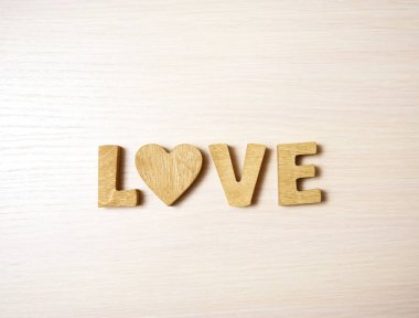 ahşap harfler ve kalp yapılan kelimesini seviyorum. ahşap arka plan. 