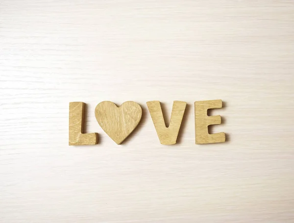 love word made from wooden letters and  heart. wooden background.