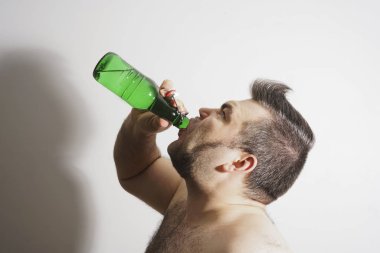 genç yetişkin adam alkol bira yeşil cam Şişeden içme.