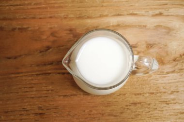 ahşap arka plan üzerinde süt cam sürahi. Üstten Görünüm 