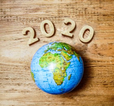 mutlu yeni yıl 2020 ahşap masa doku üzerinde yuvarlak dünya ile. Boş kopya alanı yazıt veya nesneler için