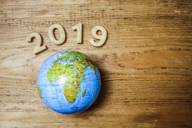 mutlu yeni yıl 2019 ahşap masa doku üzerinde yuvarlak dünya ile. Boş kopya alanı yazıt veya nesneler için