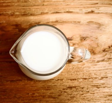 ahşap arka plan üzerinde süt cam sürahi. Üstten Görünüm 