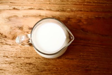 ahşap arka plan üzerinde süt sürahi. Üstten Görünüm 