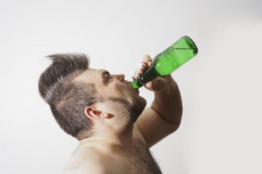 genç yetişkin adam alkol bira yeşil cam Şişeden içme.