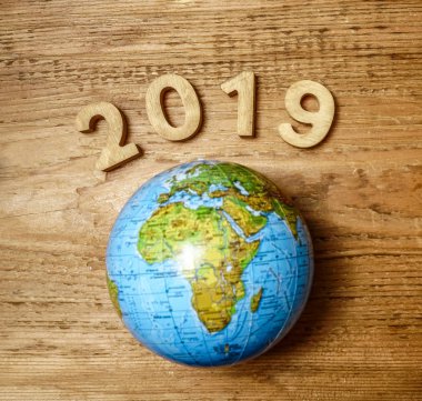 mutlu yeni yıl 2019 ahşap masa doku üzerinde yuvarlak dünya ile. Boş kopya alanı yazıt veya nesneler için