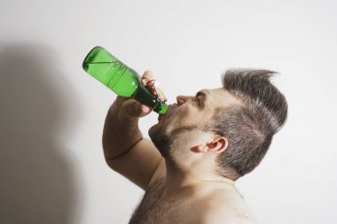 genç yetişkin adam alkol bira yeşil cam Şişeden içme.