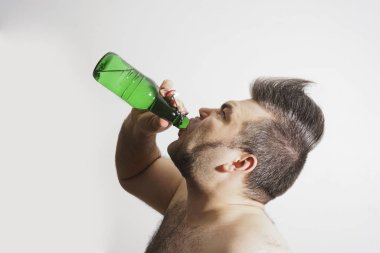 genç yetişkin adam alkol bira yeşil cam Şişeden içme.