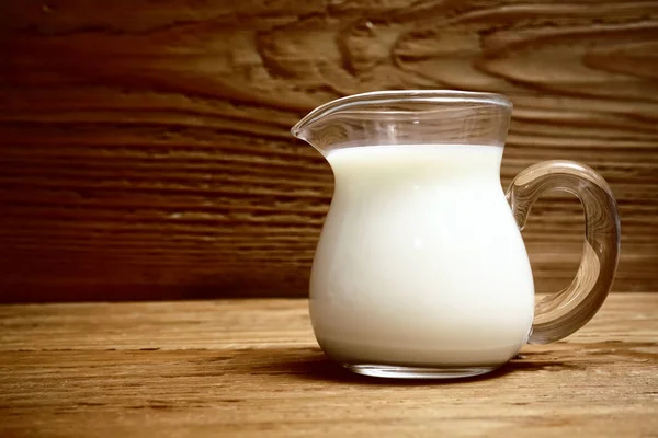 Glaskrug Mit Milch Auf Einem Hölzernen Hintergrund — Stockfoto