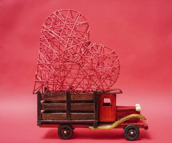 vintage wooden truck with big red heart  isolated on red  background. happy Valentines day