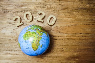 mutlu yeni yıl 2020 ahşap masa doku üzerinde yuvarlak dünya ile. Boş kopya alanı yazıt veya nesneler için