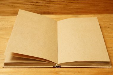 Sarı ahşap masa, üstten görünüm üstünde açık kahverengi defter. boş kopya alanı yazıt için. 