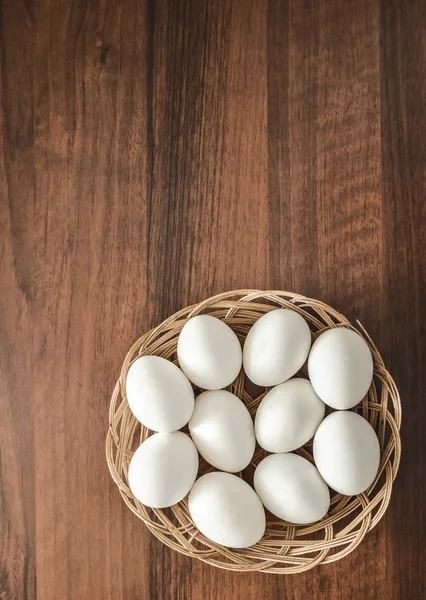 Muitos Ovos Brancos Cesta Vime Redonda Placa Madeira Uncouth Fundo — Fotografia de Stock
