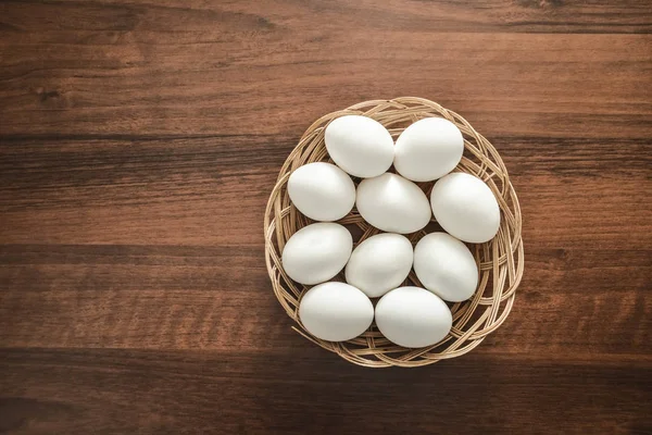 Muitos Ovos Brancos Cesta Vime Redonda Placa Madeira Uncouth Fundo — Fotografia de Stock