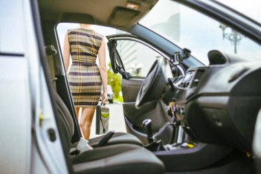 Hazırlanıyorum. Arkadan görünüşü genç yetişkin seksi iş kadını araba ile açılan kapı dışarı gidiyor. Boş otomatik iç iç. 