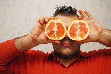genç adam greyfurt tamamlayan bir dürbün olarak kullanmak bahanesi. Büyük gözleri greyfurt tatlısı