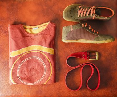 Düz yatıyordu kahverengi süveter ve kompozisyonu ayakkabı, deri arka plan üzerinde kırmızı kemer