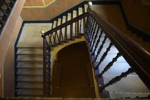 An old stone concrete staircase in the entrance of the building. Poor quarter, interior of old house. historical house. public building. stairs with wooden railings.