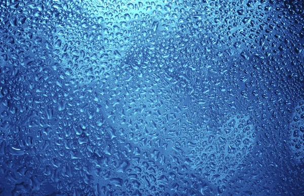蓝色窗玻璃上有许多水滴 — 图库照片