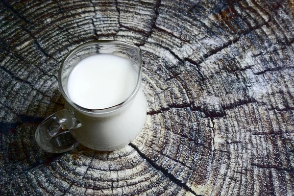 Krug Milch Auf Einem Baumstumpf Hintergrund — Stockfoto