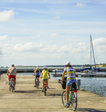 sahilde bisiklete binen mutlu aile. geri, anne, baba ve iki kızı arka görünümü