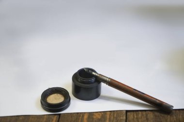 ahşap masada boş harf ile mürekkep ve tüy dolma kalem.