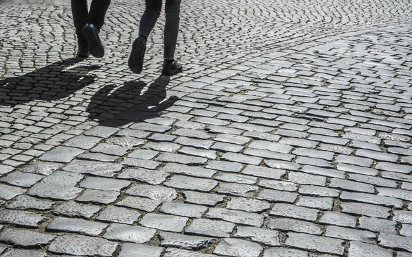 Close up image of a Romantic couple\'s legs walking down the street in europe.