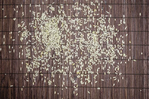 白色米在棕色竹子背景 天然背景上的有机大米 平坦的布局 顶视图 — 图库照片