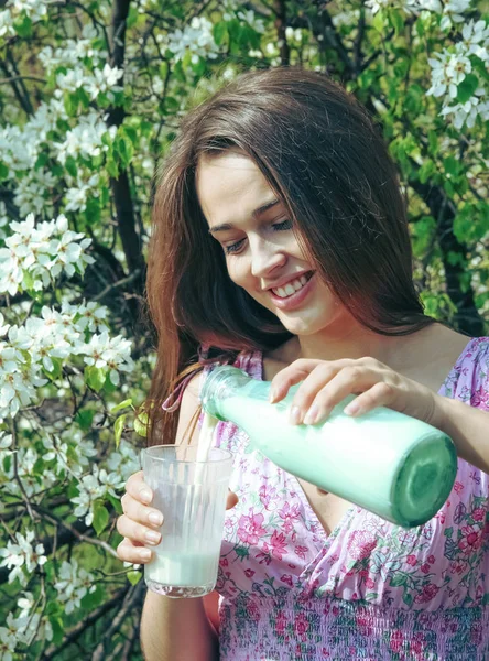 肖像成人拉丁裔少妇从瓶牛奶的杯子里倒牛奶 — 图库照片