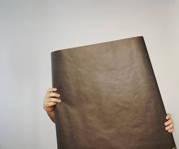 man with  black sheet of paper -unrecognizable person