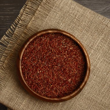 Siyah ahşap masa arka planda ahşap çanak kahverengi kuru pirinç. 