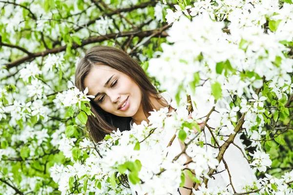 美丽的自然黑发拉美裔妇女在开花苹果树的春天庭院的画像 — 图库照片