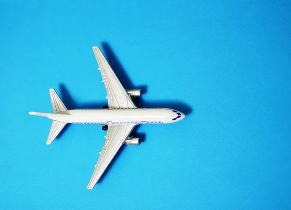 メタルトイ ブルーペーパーの背景に飛行機 ブルーの背景に孤立した現代の平面 — ストック写真