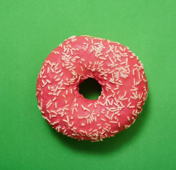 red  donut on green background. empty copy space for inscription.