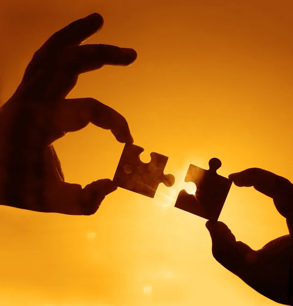 hands  with  puzzle pieces with  sky background.