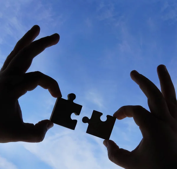 Puzzle Parçaları Mavi Gökyüzü Arka Plan Üzerinde Elleriyle — Stok fotoğraf