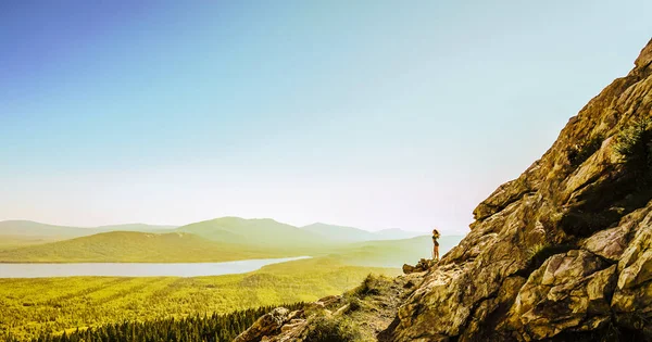 Hiker woman standing.  Successful woman hikeron sunrise mountain top. Girl in the mountains.