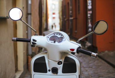 Riga, Letonya - 30 Nisan 2019: Vespa beyaz Scooter eski dar Avrupa caddesinde.