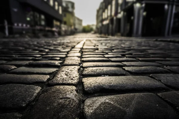 道路に見られる光の反射と黒い石畳の石畳の道路の背景 黒または濃い灰色の石畳のテクスチャ 石畳の明かり — ストック写真