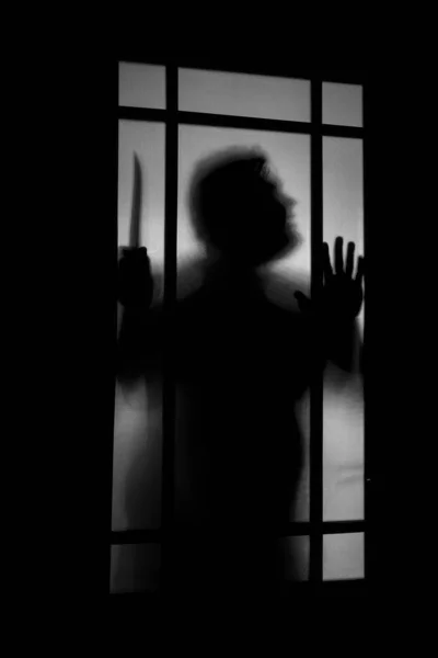 Person shadow on Frosted glass - violence concept background. shadow of a horror man