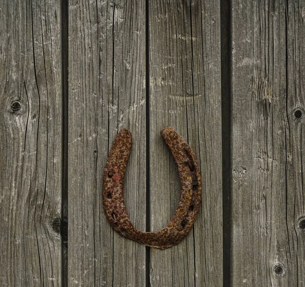 幸运生锈的马蹄铁在一个老木门 — 图库照片