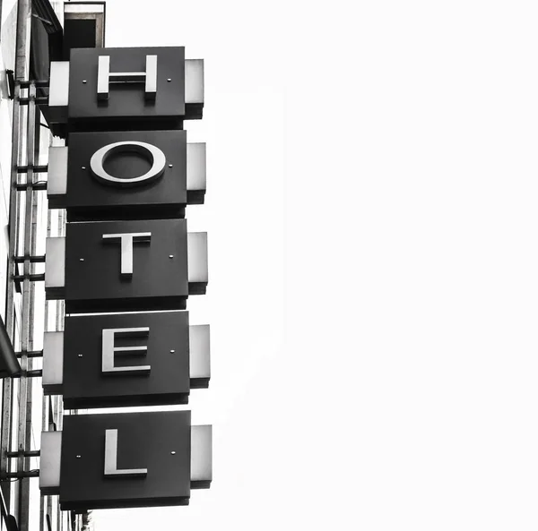 白い空の下にホテルという言葉を持つネオンサイン — ストック写真