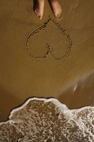 Genç Adam Kuma Ayağıyla Kalp Çiziyor Sarı Kumlu Bir Sahilde — Stok fotoğraf