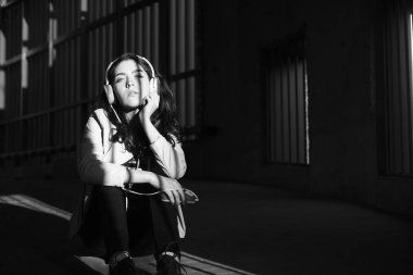 Neşeyle dinleniyor. Güzel genç kadın müzik dinlerken ve katta oturan 