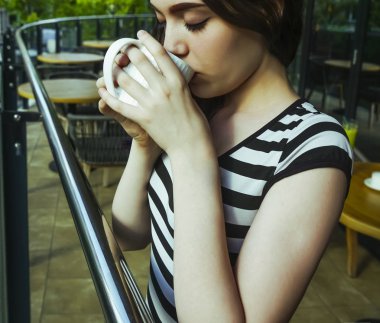 Sakin sabah genç kız lüks otel balkonunda içecek manzarası zevk kahvaltı kahve içme rahatlatıcı, yaz seyahat tatilleri. Evde yaşam.