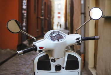 Riga, Letonya - 30 Nisan 2019: Vespa beyaz Scooter eski dar Avrupa caddesinde.